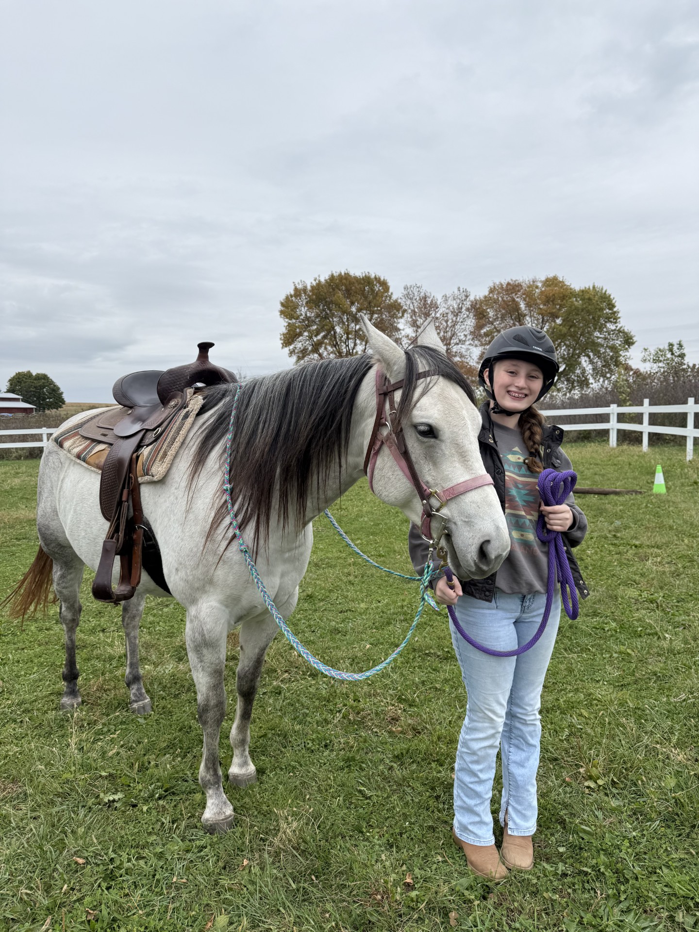 A young rider leading Dakota in the pasture